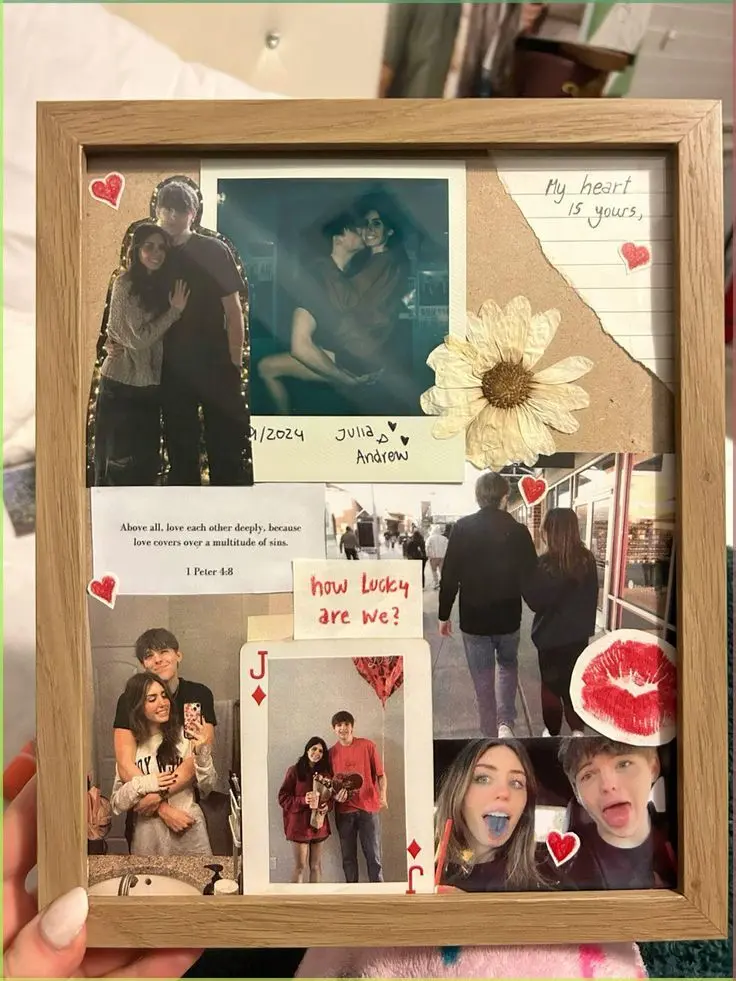 A wooden frame displays a collage of a couple's photos, handwritten notes, a dried flower, and a playing card. It conveys love and affection with hearts and a romantic tone.